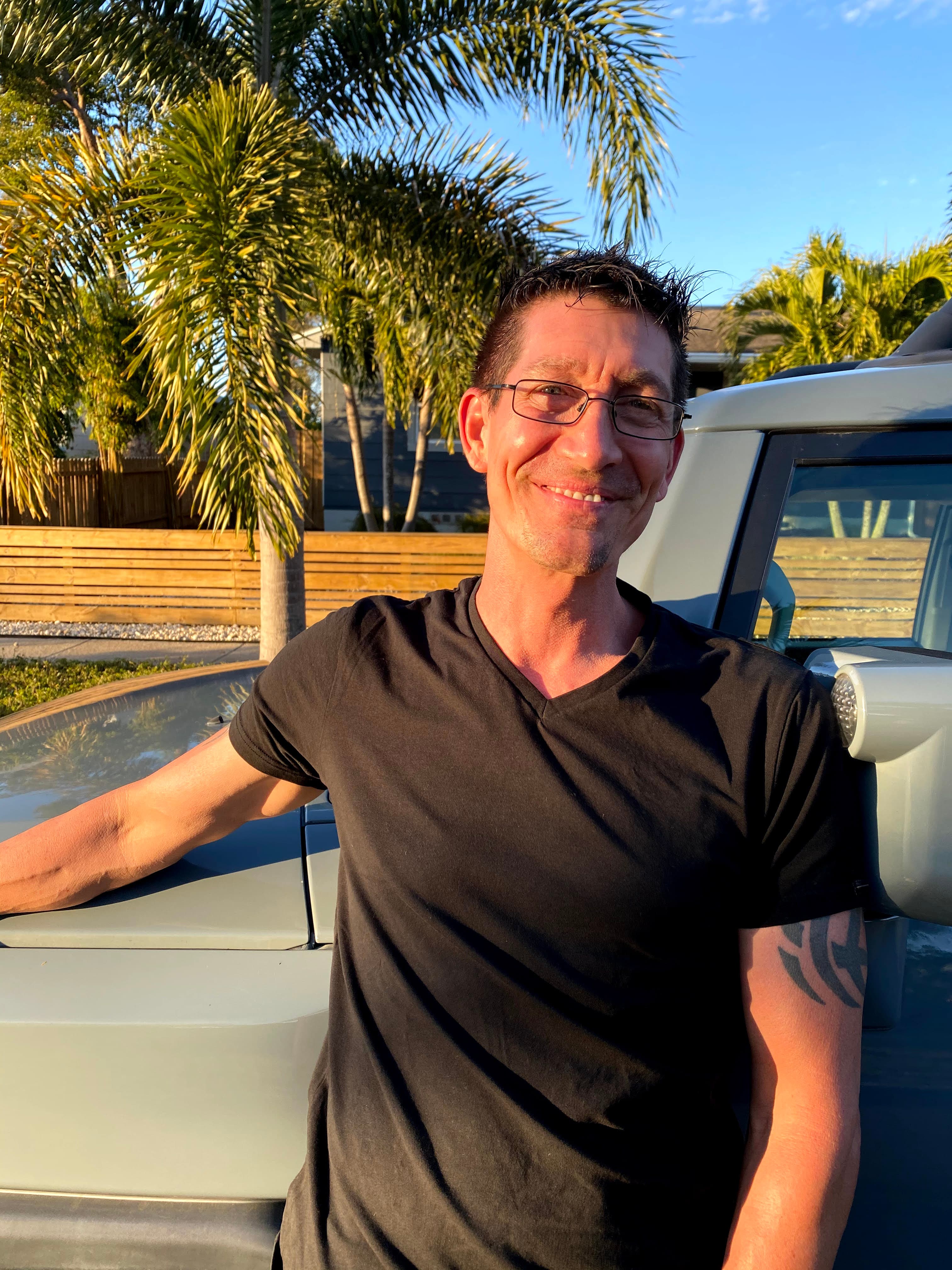 Scott Onstad — founder of Stat Incorporated, leaning against his truck at sunset in St. Petersburg, FL